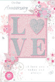 This anniversary card design offers a soft celebration of lasting romance, its colours a careful blend of pastel pinks, pearly whites, and silvery greys that bring to mind the delicate tones of spring blossoms around Bethnal Green. At the centre, the word LOVE is spelled out in elegant, raised glitter lettering, with the O transformed into a shimmering heart textured in silver. The heart looks almost like a tiny, polished charm resting upon the card, adding a touch of depth and a focal point the fingers would naturally seek. Surrounding this emblem, clusters of illustrated blooms in blush, mauve, and pale cream drift across the surface, their petals rendered with a watery softness that feels like a hand-painted wash. Fine swirling lines, scattered petals, and discreet butterflies weave between the flowers, giving the sense of a gentle breeze passing through an English spring garden not far from Bethnal Green Gardens. The background is a muted pink wash, allowing the silvery details to glimmer without distraction. At the top and lower sections of the card, phrases such as On Our Anniversary and I love you today and always appear in an understated, flowing script that speaks with quiet sincerity. The composition feels balanced and intimate, like a carefully chosen bouquet delivered to a townhouse near Roman Road, meant to be kept on a bedside table as a reminder of a shared journey. Every element-from the sparkling heart to the soft florals-works together to convey devotion, tenderness, and the kind of love that deepens with each passing year in Bethnal Green.